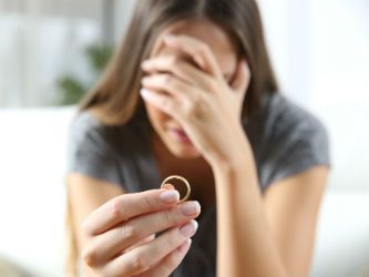 Woman crying and handing over wedding ring after infidelity