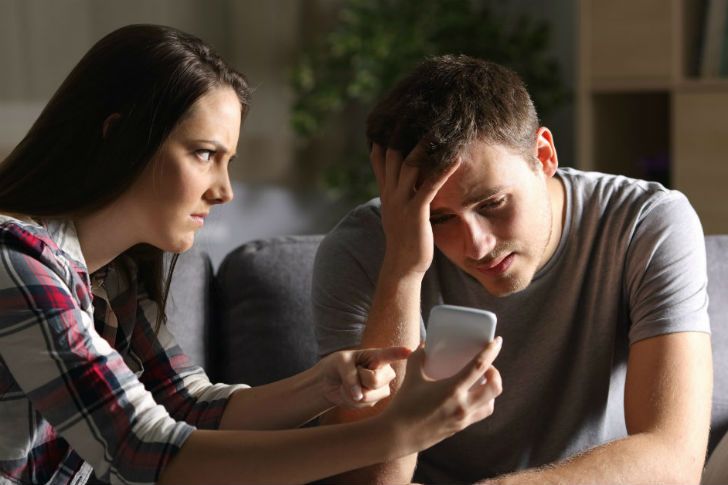Cheating husband being called out by wife showing him on her cell phone